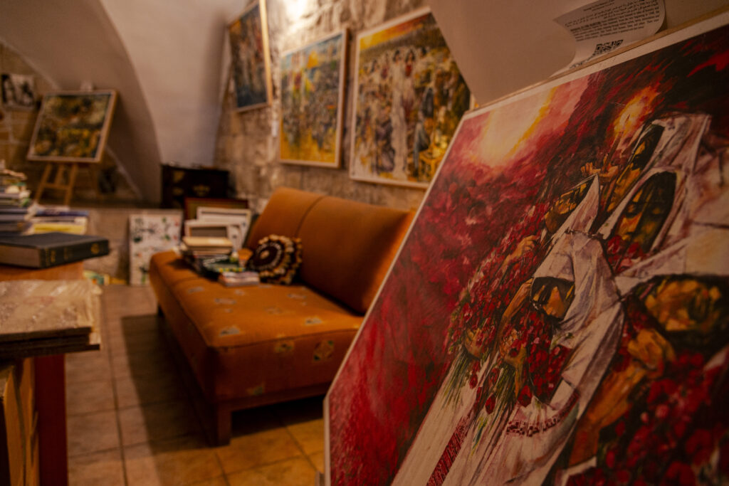One of the rooms in the Dar Zahran house museum. In the photo, a painting taken at an angle depicts women crying on a blood-red background. In the background, the rest of the room, with the walls covered with paintings from the same series.
