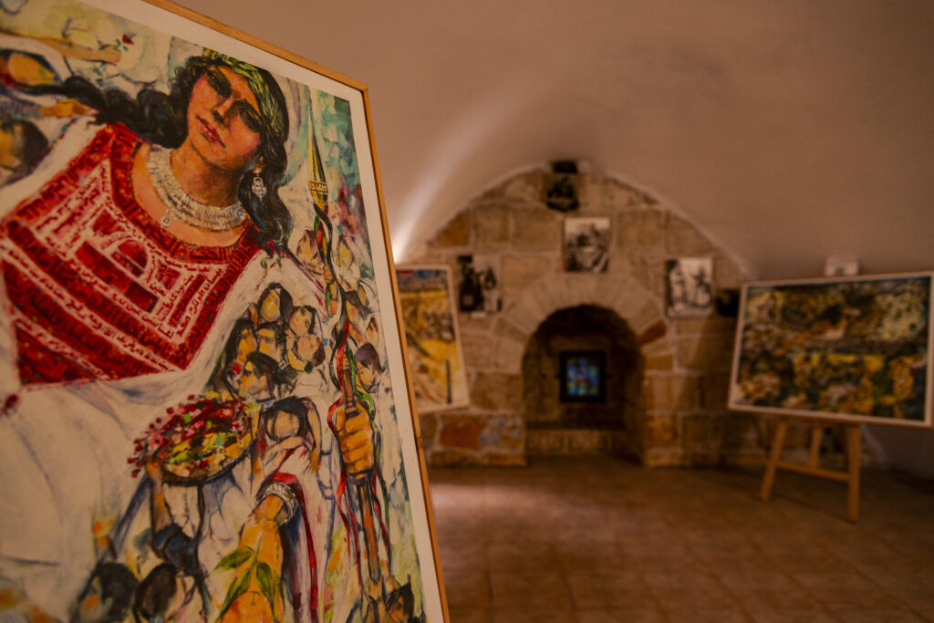 Another painting inside the Dar Zahran house museum. Palestinians gather around a woman representing the land of Palestine.