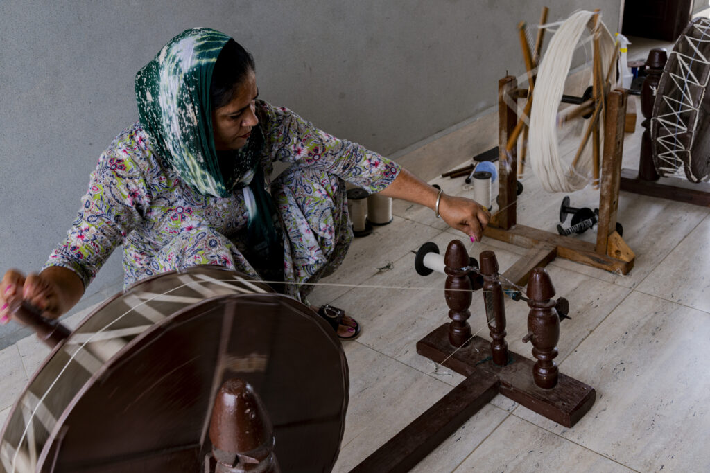 A woman from the weaving school of the Kheti Virasat Mission organization in Jaitu town. The woman works at the spinning wheel.